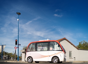 un petit bus blanc et rouge est garé sur le bord de la route.